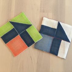 two pieces of cloth sitting on top of a wooden floor next to each other with different colors