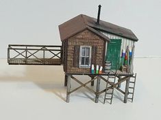 there is a small house on stilts with a ladder going up to the roof