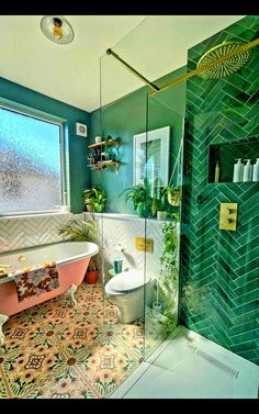 a bathroom with green tiles and a pink bathtub next to a window in the corner