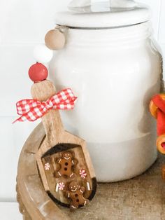 a wooden spoon sitting on top of a table next to a jar and teddy bear