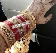 a woman with henna and bracelets on her arm holding onto a car seat