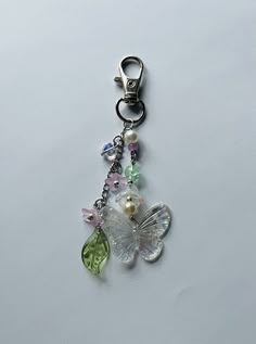 a keychain with a butterfly and flower charm hanging from it's side