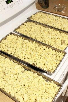 four pans filled with food sitting on top of an oven