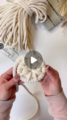 someone is holding a rope and making something out of it on the table with other items