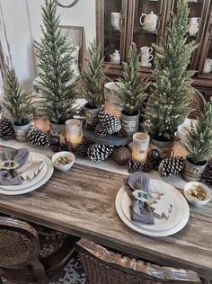 the table is set with pine cones and candles