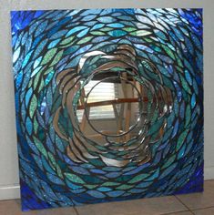 a blue and green stained glass window in the shape of a circular design on a tile floor