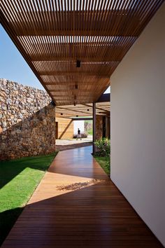 the walkway is lined with stones and grass, leading to an open area that has a stone wall on one side