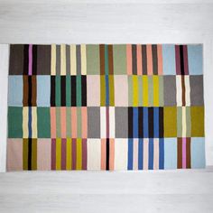 a multicolored rug is hanging on the wall