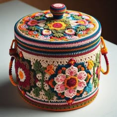 a multicolored crocheted box sitting on top of a table