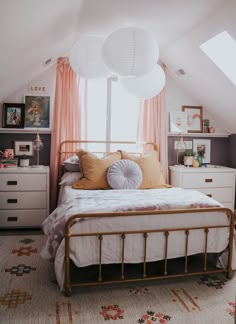 a white bed sitting under a window next to a dresser and drawers in a bedroom