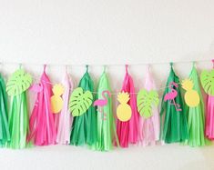 tissue tassels with pineapple, flamingo and palm leaves hanging on a string