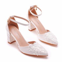 a pair of white wedding shoes with flowers on the heel and ankle strap, all in satin