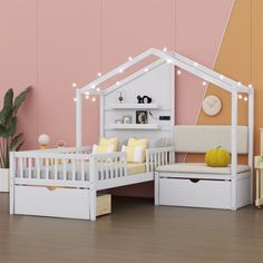 a dollhouse bed with white furniture and lights on the top shelf, in front of a pink wall