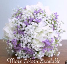 a bouquet of white and purple flowers on a table