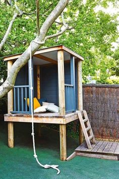 a small wooden tree house with stairs to the roof