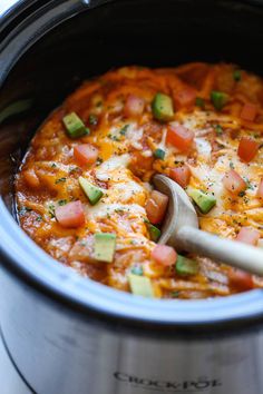 a slow cooker filled with mexican food and garnished with avocado