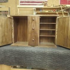 an empty bed frame in a room with wooden furniture and american flag hanging on the wall