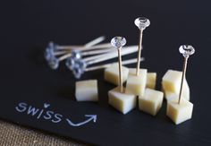 several pieces of cheese are arranged on a black surface with the word swiss written below them