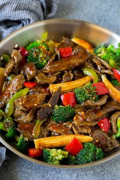 a bowl filled with beef, broccoli and peppers