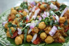 a green plate topped with chickpeas and onions