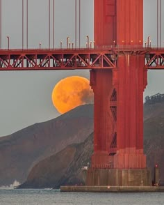 the full moon is setting over the golden gate bridge