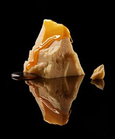 a piece of cake is being drizzled with caramel sauce on a black background