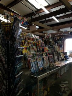 there are many magazines on the shelves in this store that is filled with comic books