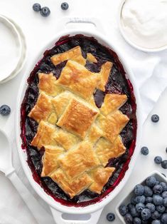 blueberry pie in a white dish with fresh berries on the side