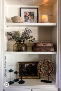 the shelves are filled with vases, pictures and other decorative items on top of them