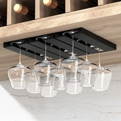 several wine glasses are hanging from the ceiling