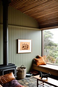 a living room filled with furniture and a fire place next to a wall mounted wood burning stove