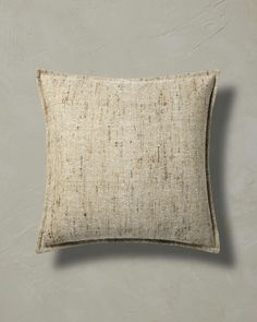 a white pillow on top of a gray wall