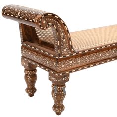 a bench made out of wood and wicker with an intricately carved seat on it