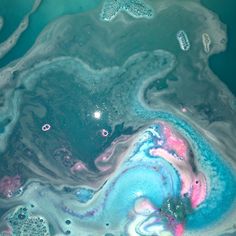 an aerial view of some blue and pink liquid in the water with starfish on it