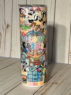 a colorful cup sitting on top of a wooden table