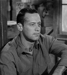 black and white photograph of a man sitting at a table looking off to the side