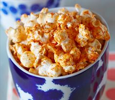 a blue and white bowl filled with popcorn