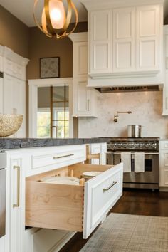 an open drawer in the middle of a kitchen