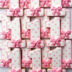 pink and white decorated cookies arranged in the shape of numbers with bowknots