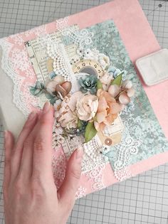 someone is making a card with lace and flowers