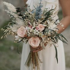 a woman holding a bouquet of flowers in her hands