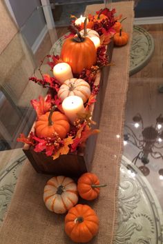 a table with candles and pumpkins on it