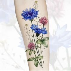 a woman's leg with flowers painted on it and an arm tattoo design in blue