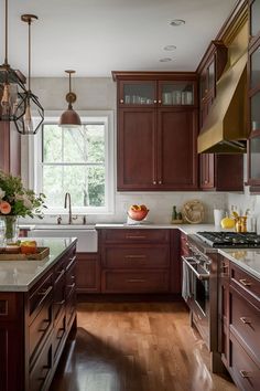 a kitchen filled with lots of wooden cabinets and counter top space next to a window