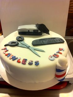 a white cake with scissors and writing on it