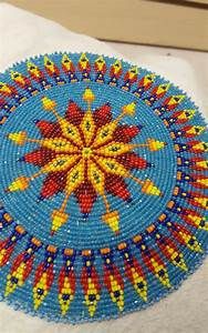 a blue and yellow beaded doily sitting on top of a white towel