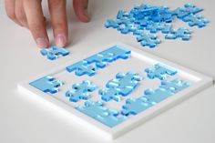 a person is playing with puzzle pieces on the table