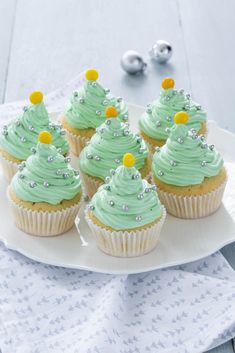 cupcakes decorated with green frosting on a white plate