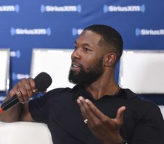 a man with a beard sitting in front of a microphone