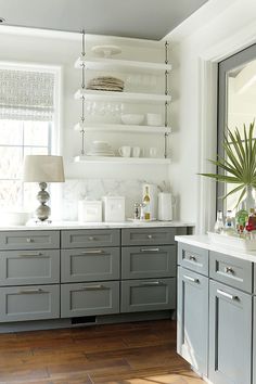 a kitchen with gray cabinets and white walls is featured in the instagramtor's website